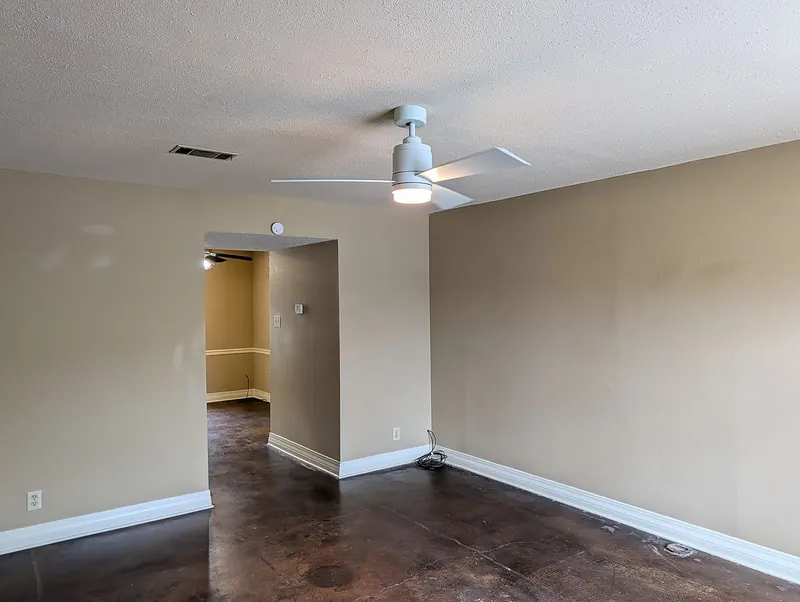 Living area with ceiling fan and doorway to the kitchen