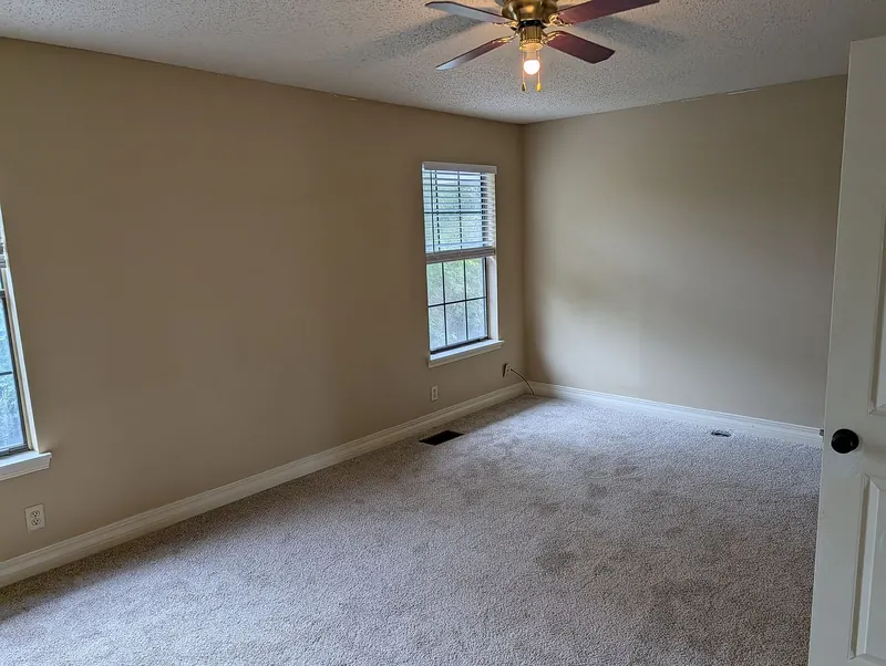 Bedroom with new carpet and a window
